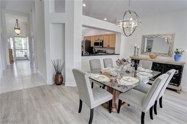 dining area featuring an inviting chandelier and light hardwood / wood-style flooring