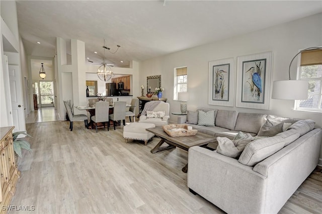 486 Edgemere Way E Unit 2-3, Naples, FL 34105 - living room with a chandelier, lofted ceiling, and light wood-style floors