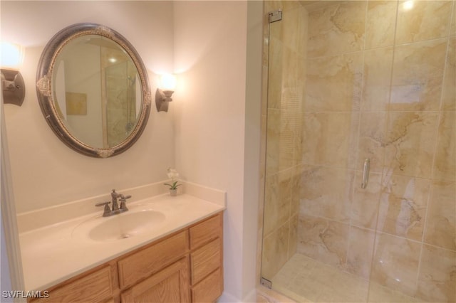 bathroom featuring a shower with door and vanity