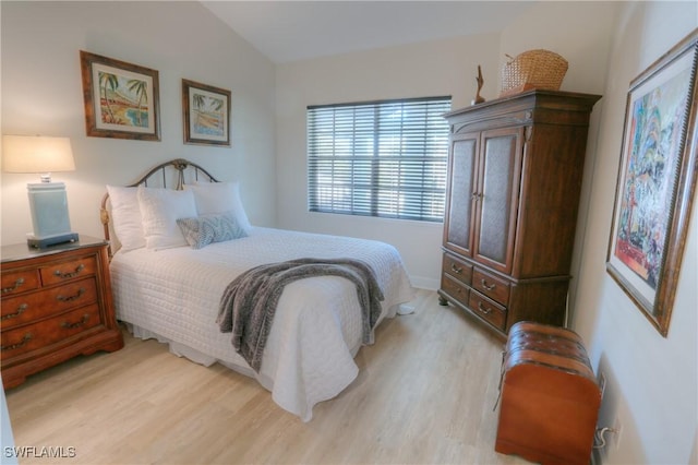 bedroom featuring light hardwood / wood-style flooring and lofted ceiling