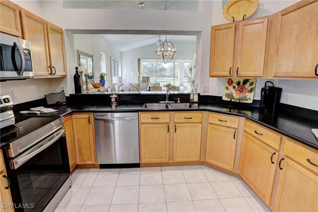 486 Edgemere Way E Unit 2-3, Naples, FL 34105 - kitchen featuring stainless steel appliances, dark countertops, light tile patterned floors, a chandelier, and lofted ceiling