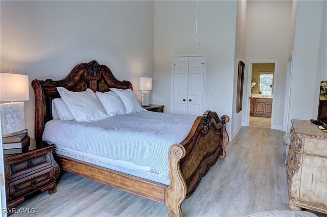 486 Edgemere Way E Unit 2-3, Naples, FL 34105 - bedroom featuring a towering ceiling, light wood finished floors, ensuite bathroom, and a closet