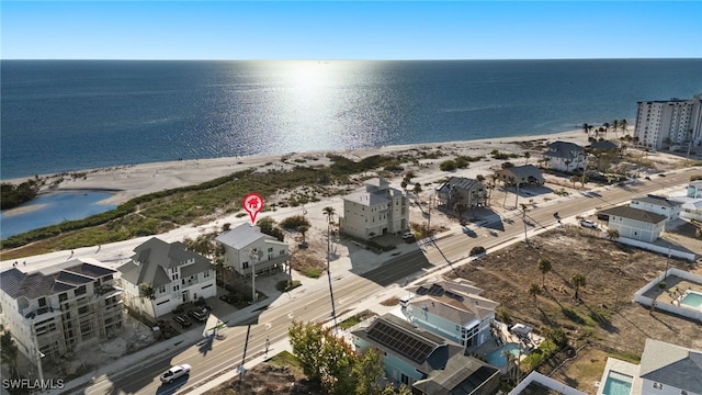 birds eye view of property with a water view and a beach view