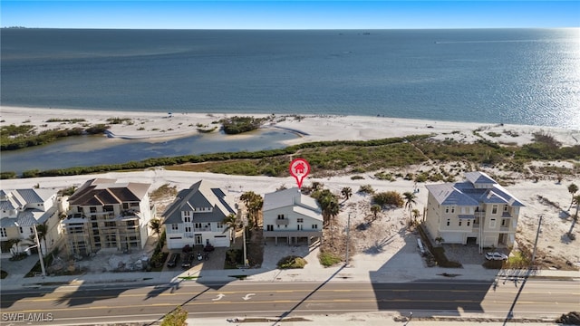 drone / aerial view with a water view and a beach view