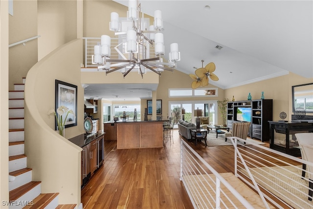 living room featuring a healthy amount of sunlight, hardwood / wood-style flooring, high vaulted ceiling, and a notable chandelier