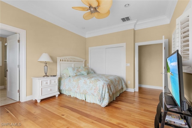 bedroom with a closet, light hardwood / wood-style flooring, ceiling fan, and crown molding