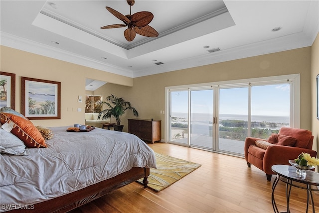 bedroom featuring ceiling fan, crown molding, a tray ceiling, access to outside, and light wood-type flooring