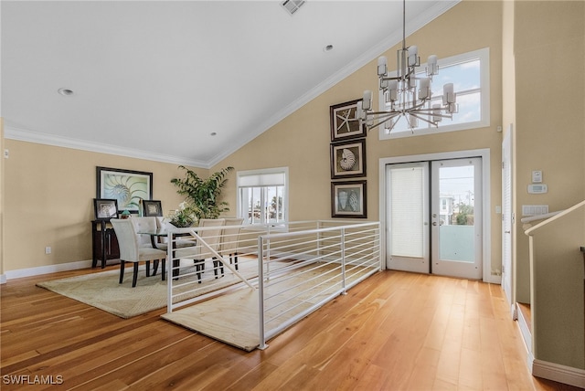 foyer entrance featuring a chandelier, wood-type flooring, plenty of natural light, and ornamental molding