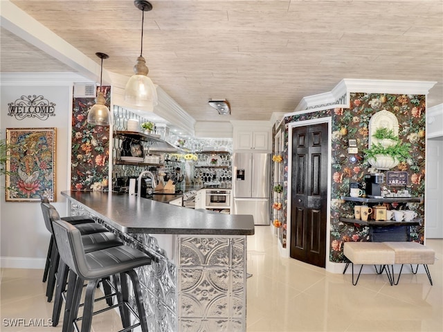 kitchen with kitchen peninsula, a kitchen breakfast bar, stainless steel appliances, sink, and pendant lighting