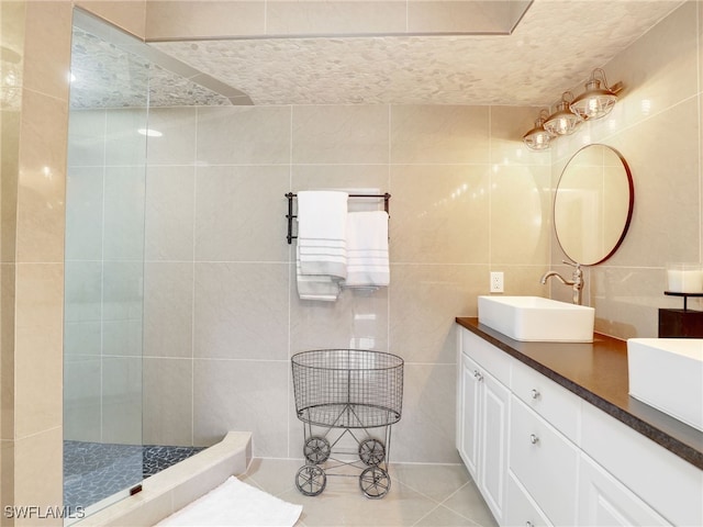 bathroom featuring tile patterned floors, vanity, tile walls, and walk in shower