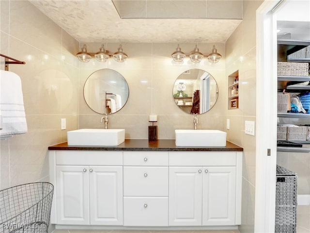 bathroom featuring vanity and tile walls