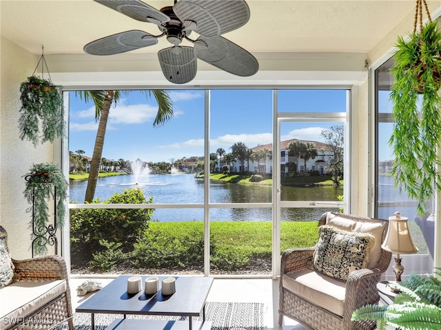 sunroom / solarium with ceiling fan and a water view