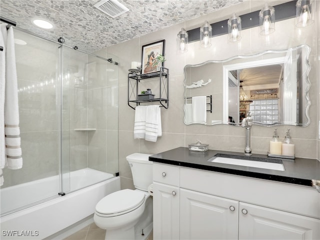 full bathroom with backsplash, bath / shower combo with glass door, vanity, tile walls, and toilet