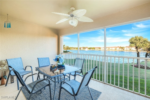 sunroom / solarium featuring ceiling fan and a water view