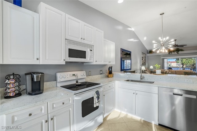 kitchen featuring lofted ceiling, white appliances, an inviting chandelier, sink, and hanging light fixtures