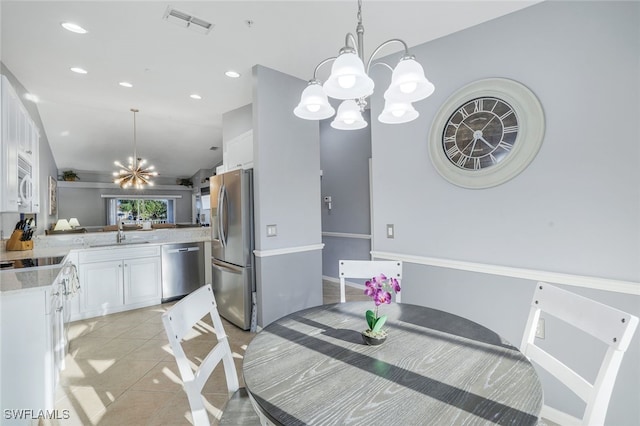 dining space with light tile patterned floors, a chandelier, and vaulted ceiling