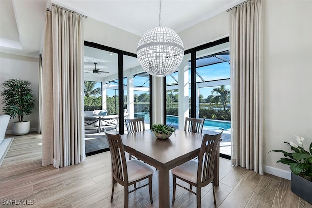 dining area featuring light hardwood / wood-style floors, ceiling fan with notable chandelier, and ornamental molding