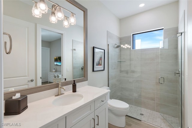 bathroom featuring hardwood / wood-style flooring, vanity, toilet, and a shower with shower door