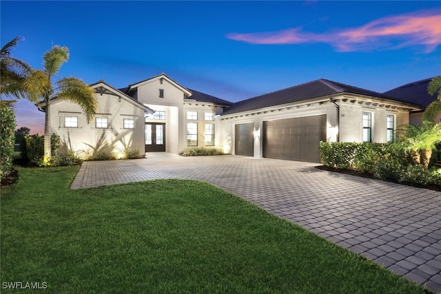 view of front of home with french doors, a yard, and a garage