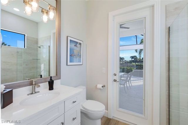 bathroom featuring hardwood / wood-style floors, vanity, a shower with shower door, and toilet