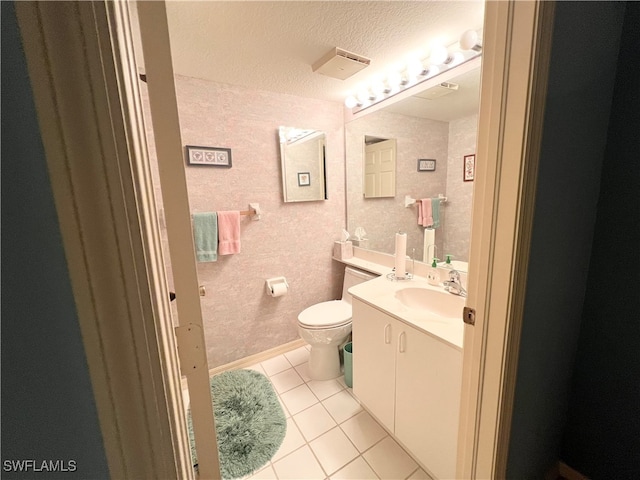 bathroom featuring tile patterned floors, vanity, a textured ceiling, and toilet