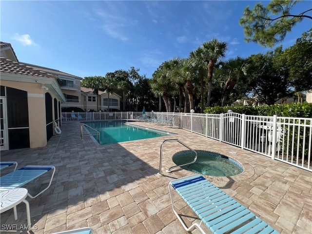 view of pool featuring a hot tub and a patio area