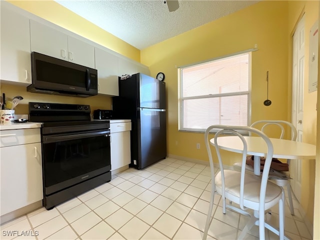 kitchen featuring white cabinetry, light tile patterned floors, black appliances, and a textured ceiling