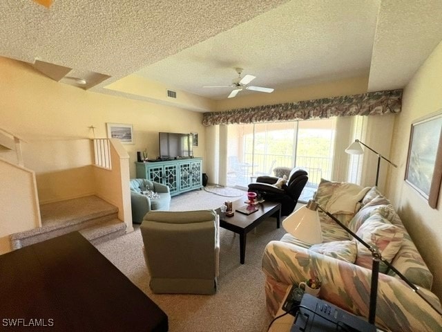 carpeted living room featuring a textured ceiling and ceiling fan