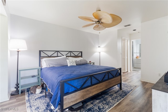 bedroom with a closet, ensuite bath, ceiling fan, and hardwood / wood-style floors