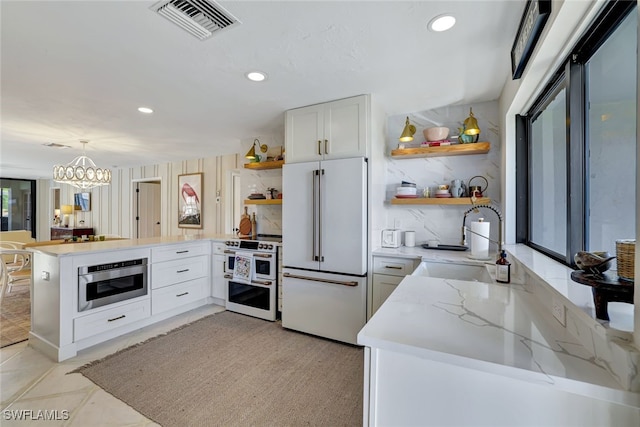 kitchen with white cabinetry, sink, hanging light fixtures, kitchen peninsula, and white appliances