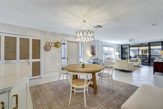 dining area with ceiling fan with notable chandelier and light tile patterned flooring