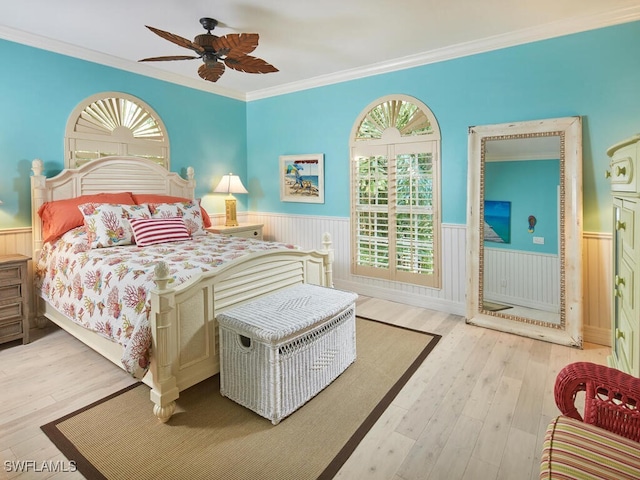 bedroom featuring ceiling fan, light hardwood / wood-style flooring, and ornamental molding