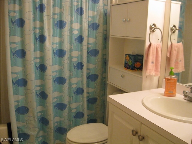 bathroom with a shower with shower curtain, vanity, and toilet