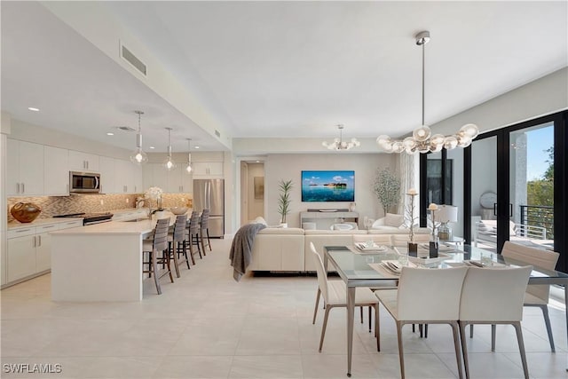 tiled dining space featuring sink and a notable chandelier