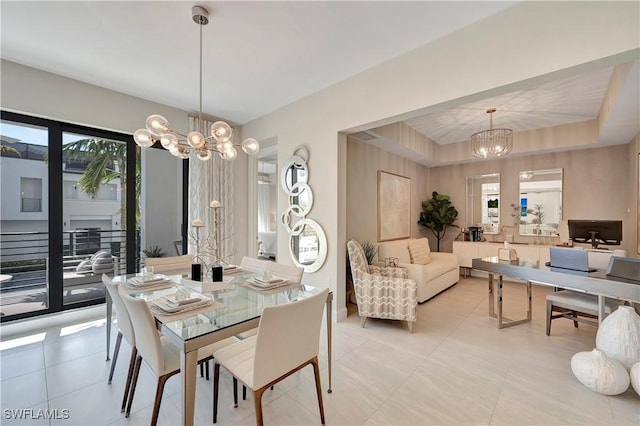 tiled dining area with a raised ceiling, an inviting chandelier, and plenty of natural light