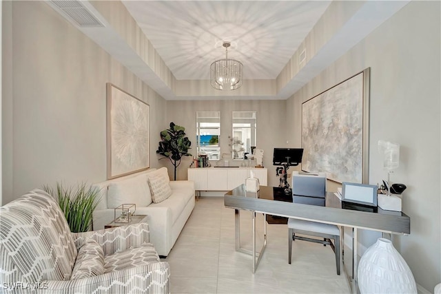 home office with a tray ceiling and an inviting chandelier