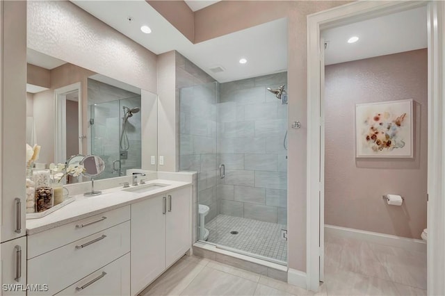 bathroom with tile patterned floors, vanity, an enclosed shower, and toilet