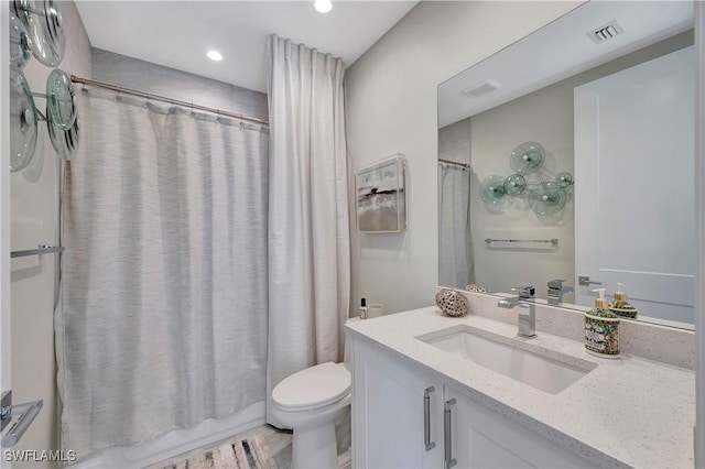 full bathroom featuring hardwood / wood-style floors, vanity, toilet, and shower / tub combo