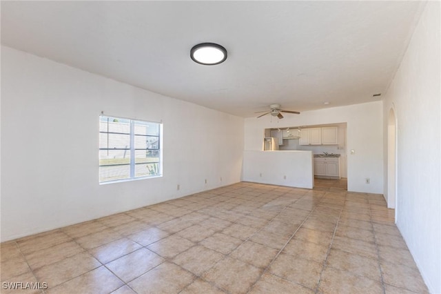 unfurnished living room with ceiling fan