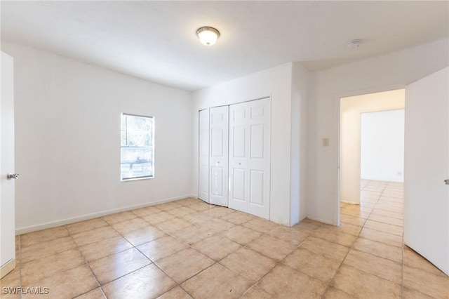 unfurnished bedroom with light tile patterned floors and a closet