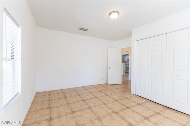 unfurnished bedroom with a closet and light tile patterned floors