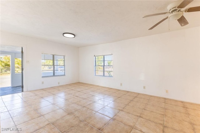 empty room with light tile patterned floors and a wealth of natural light