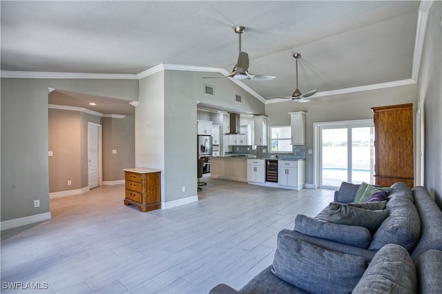 living room with lofted ceiling, light hardwood / wood-style floors, ornamental molding, and beverage cooler