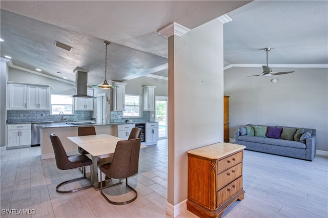 dining area with crown molding, light hardwood / wood-style flooring, beverage cooler, and vaulted ceiling