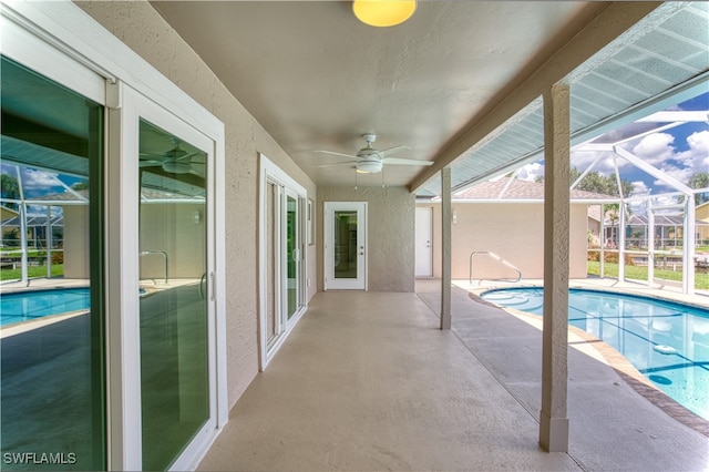 view of pool with a lanai, ceiling fan, and a patio area