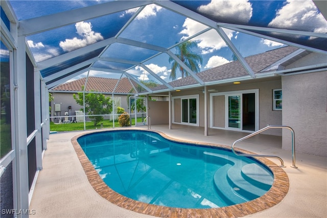 view of swimming pool featuring glass enclosure and a patio area