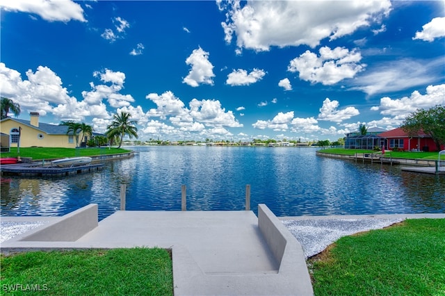 dock area featuring a lawn and a water view