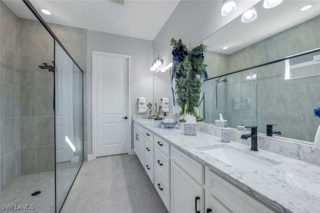 bathroom featuring tile patterned flooring, vanity, and tiled shower