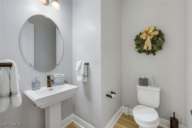 bathroom with hardwood / wood-style flooring and toilet