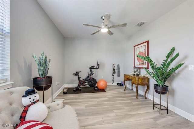 workout room featuring light wood-type flooring and ceiling fan